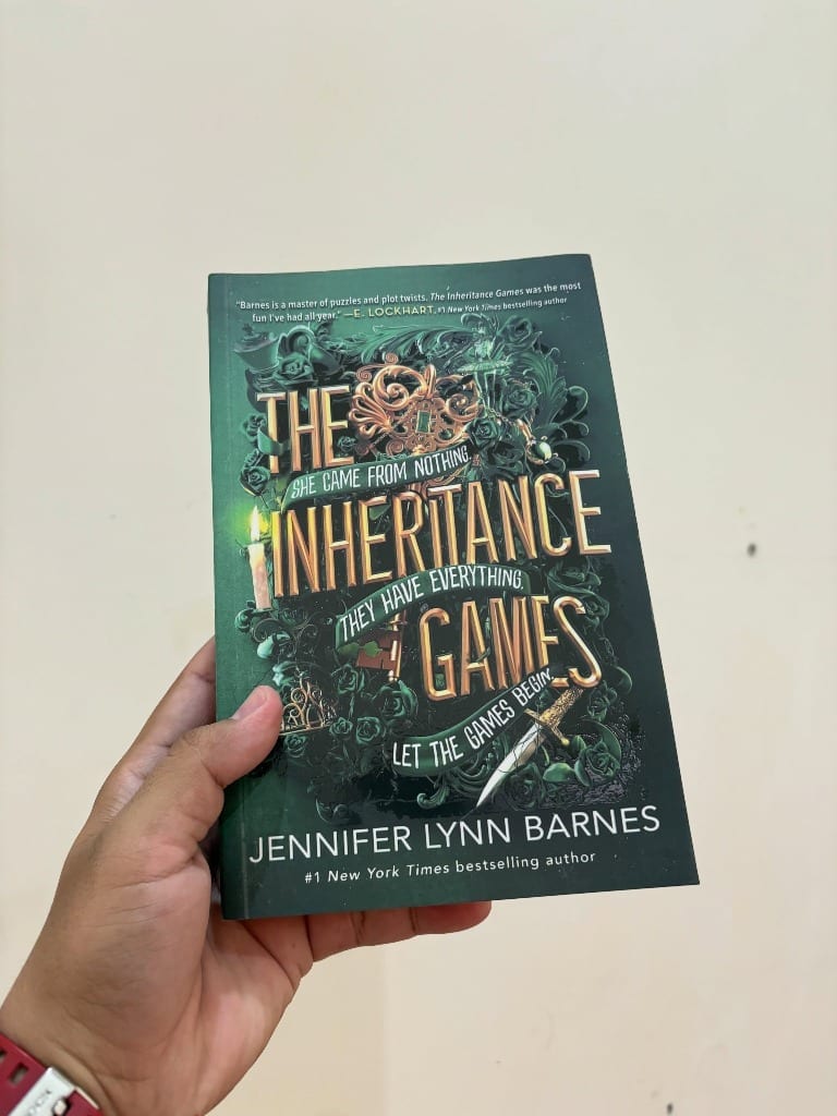 The Inheritance Games by Jennifer Lynn Barnes held in hand